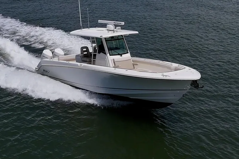 Slide: The Image of 2020 Boston Whaler 330 Outrage cruising on open water, showcasing sleek design and powerful performance. - 14