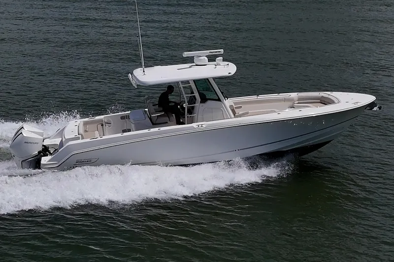 Slide: The Image of 2020 Boston Whaler 330 Outrage cruising on water, side view. - 15