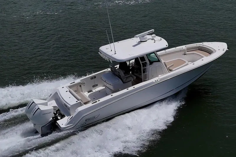 Slide: The Image of 2020 Boston Whaler 330 Outrage cruising on open water, showcasing sleek design and powerful engines. - 16