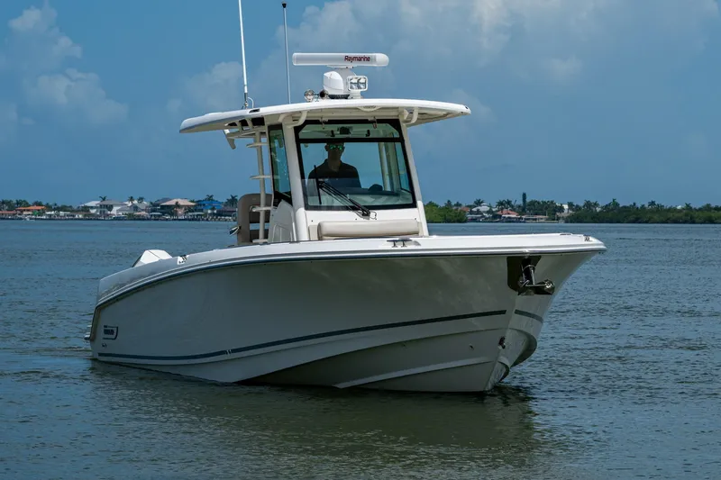 Slide: The Image of 2020 Boston Whaler 330 Outrage boat on calm water under blue sky. - 2