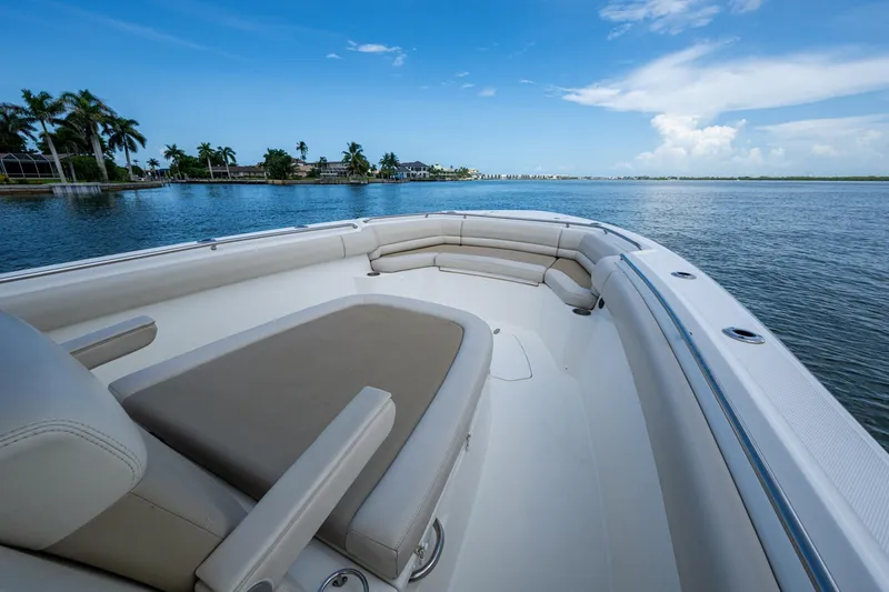 Slide: The Image of 2020 Boston Whaler 330 Outrage boat on calm water, featuring spacious seating and clear blue skies. - 25