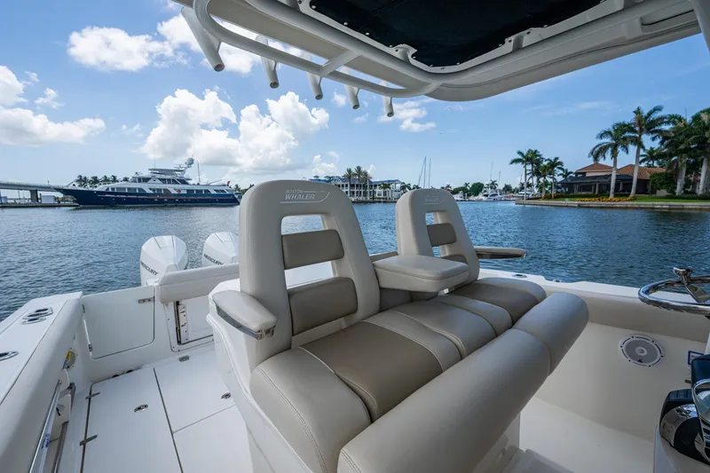 Slide: The Image of 2020 Boston Whaler 330 Outrage boat interior with luxurious seating, overlooking marina. - 28