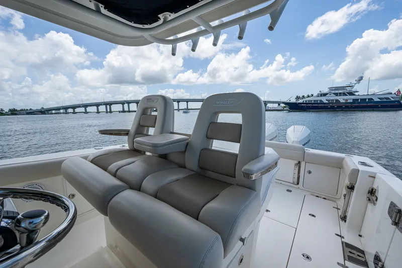 Slide: The Image of 2020 Boston Whaler 330 Outrage boat interior with luxurious seating, overlooking a scenic waterfront. - 29