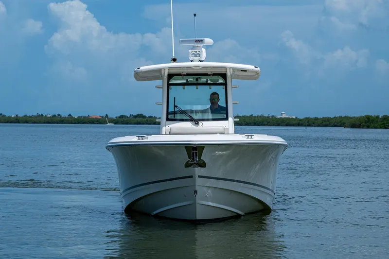 Slide: The Image of 2020 Boston Whaler 330 Outrage boat on calm water, front view. - 3
