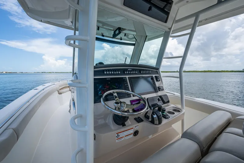 Slide: The Image of 2020 Boston Whaler 330 Outrage boat cockpit with steering wheel and navigation system. - 30