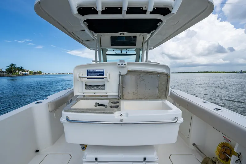 Slide: The Image of 2020 Boston Whaler 330 Outrage boat interior with open storage compartment, ocean view. - 34