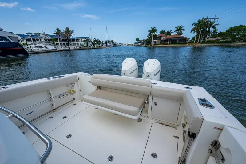 Slide: The Image of 2020 Boston Whaler 330 Outrage boat with dual engines, docked in a scenic marina. - 38