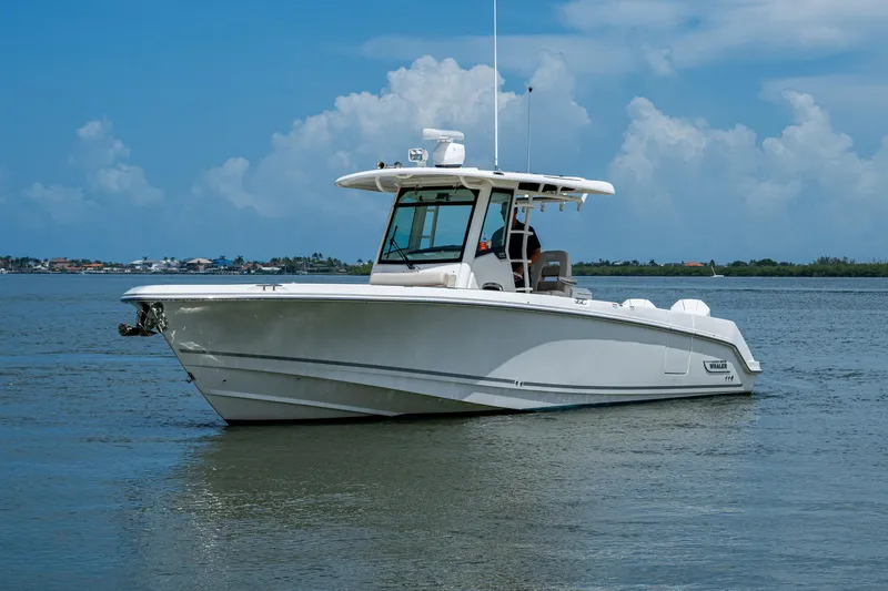 Slide: The Image of 2020 Boston Whaler 330 Outrage boat on calm water under blue sky. - 4