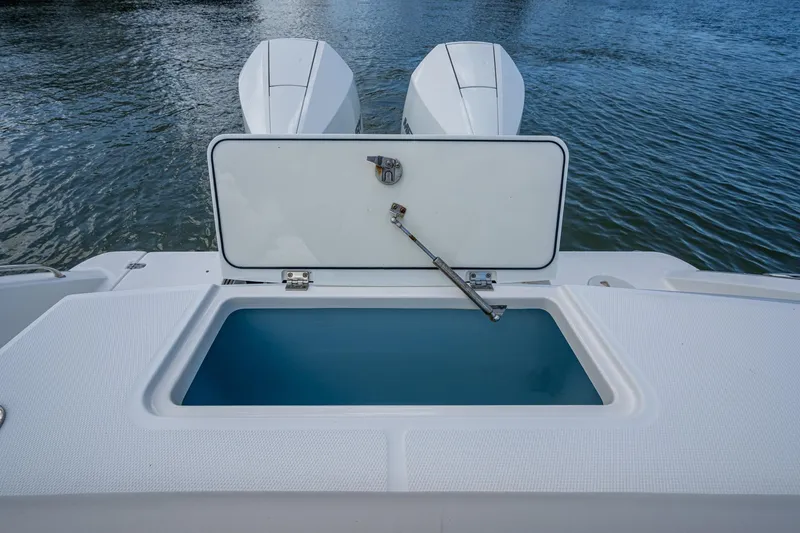 Slide: The Image of 2020 Boston Whaler 330 Outrage boat with open storage compartment, twin engines visible. - 40
