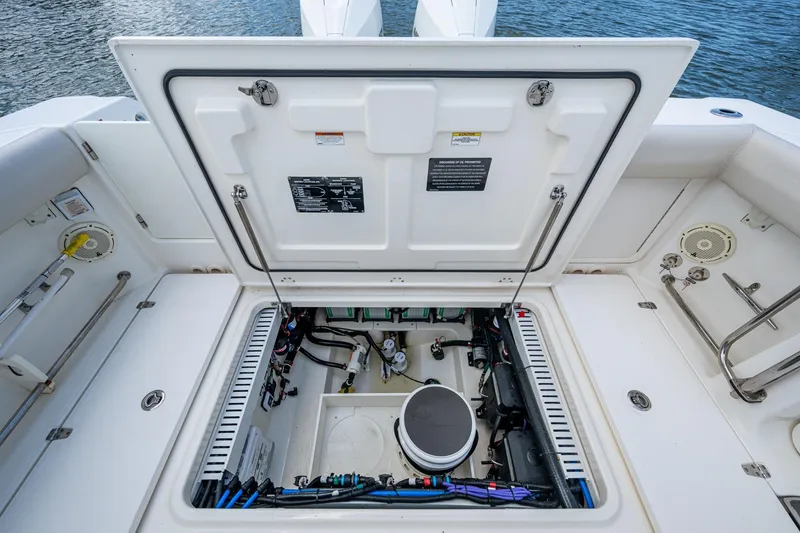 Slide: The Image of 2020 Boston Whaler 330 Outrage open hatch showing engine compartment details. - 42