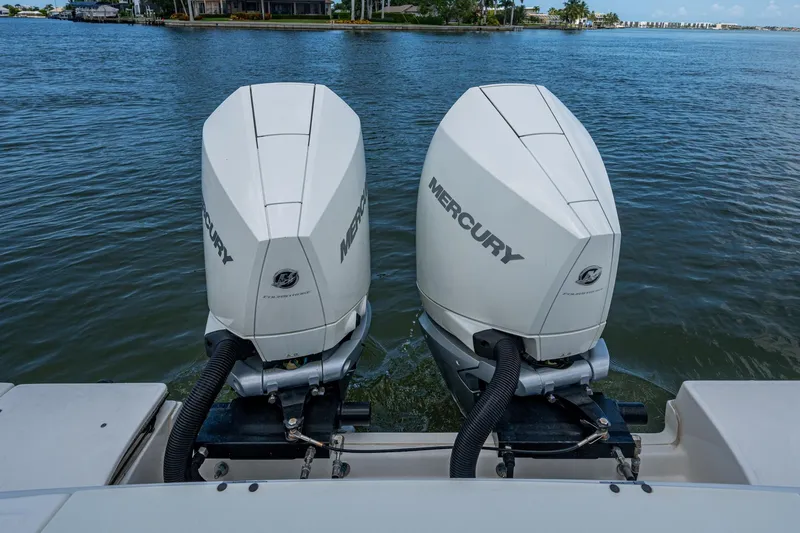 Slide: The Image of Twin Mercury outboard engines on a 2020 Boston Whaler 330 Outrage, docked on calm waters. - 45