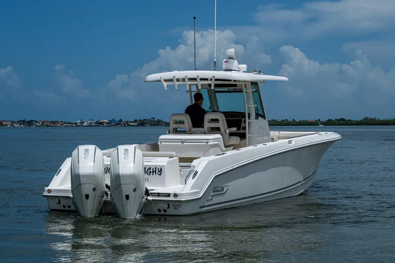 Slide: The Image of 2020 Boston Whaler 330 Outrage boat on calm water under a cloudy sky. - 9