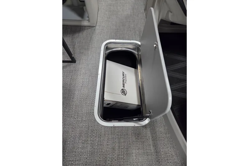 Slide: The Image of Open storage compartment in 2026 Barletta Lusso 25UC boat, featuring a Mercury box. - 14