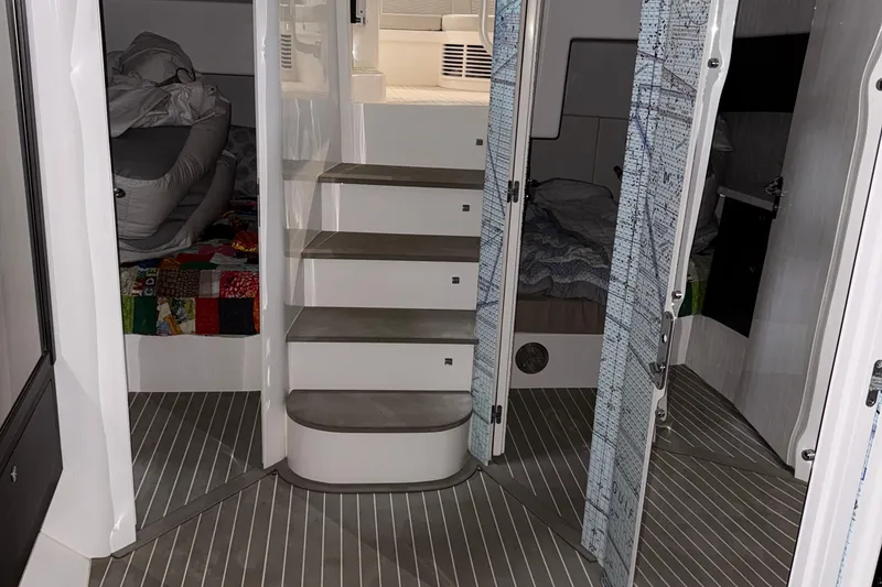 Slide: The Image of Interior of 2020 Intrepid 475 Sport Yacht, featuring stairs and cozy sleeping quarters. - 19