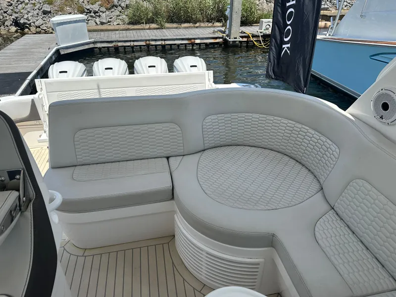 Slide: The Image of Luxurious seating on 2020 Intrepid 475 Sport Yacht, docked with outboard engines visible. - 7