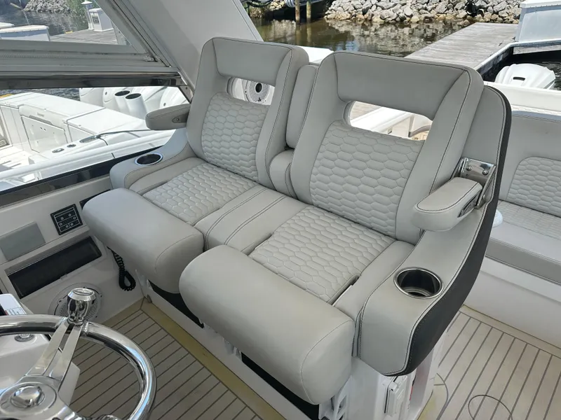 Slide: The Image of Luxurious seating on 2020 Intrepid 475 Sport Yacht, featuring plush upholstery and cup holders. - 8