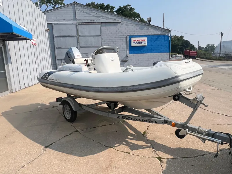 Slide: The Image of 2017 Walker Bay Generation 360 DLX boat on trailer outside Honda Marine building. - 11