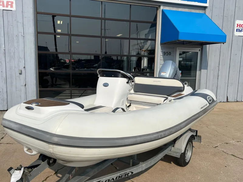 Slide: The Image of 2017 Walker Bay Generation 360 DLX inflatable boat on trailer outside a building. - 13