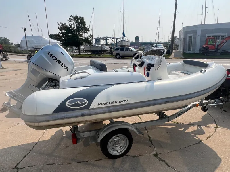 Slide: The Image of 2017 Walker Bay Generation 360 DLX boat with Honda outboard motor on a trailer. - 4
