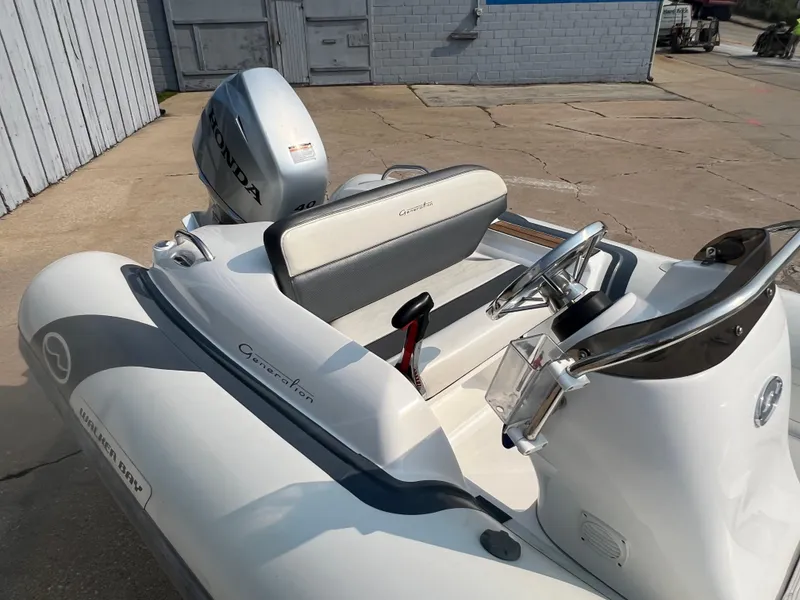 Slide: The Image of 2017 Walker Bay Generation 360 DLX boat with Honda outboard motor, parked on concrete. - 7