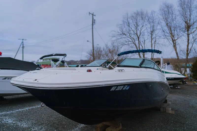 Slide: The Image of 2013 Sea Ray 220 Sundeck boat on display in a marina setting. - 0