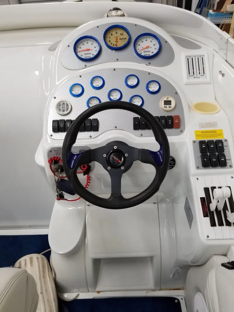 Slide: The Image of Control panel of a 2001 Baja 342 boat with gauges and steering wheel. - 8