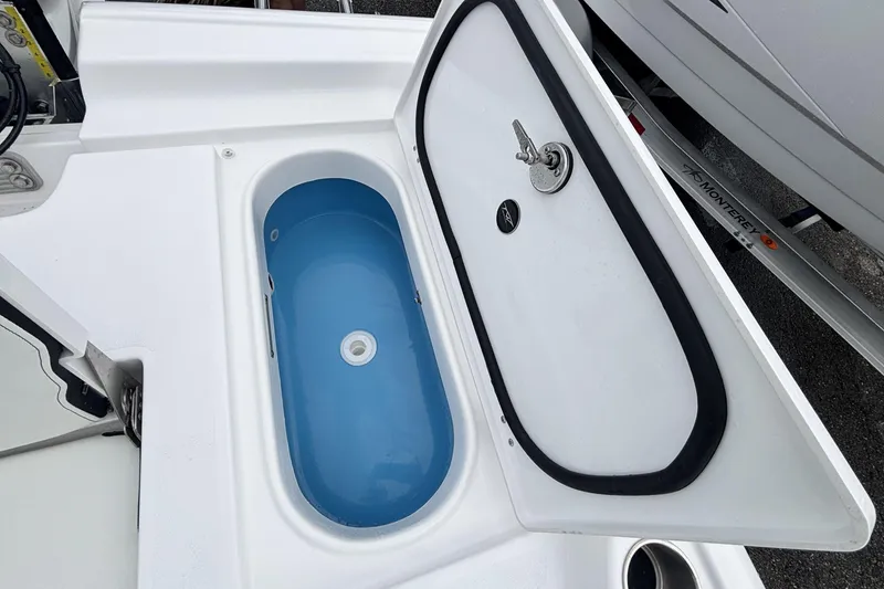 Slide: The Image of Livewell compartment on 2026 Tidewater 2300 Carolina Bay boat, featuring a blue interior. - 16