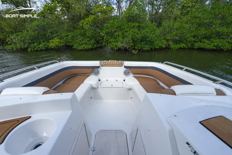 Slide: The Image of 2023 Starcraft SVX 210 boat interior with seating, surrounded by lush greenery. - 8