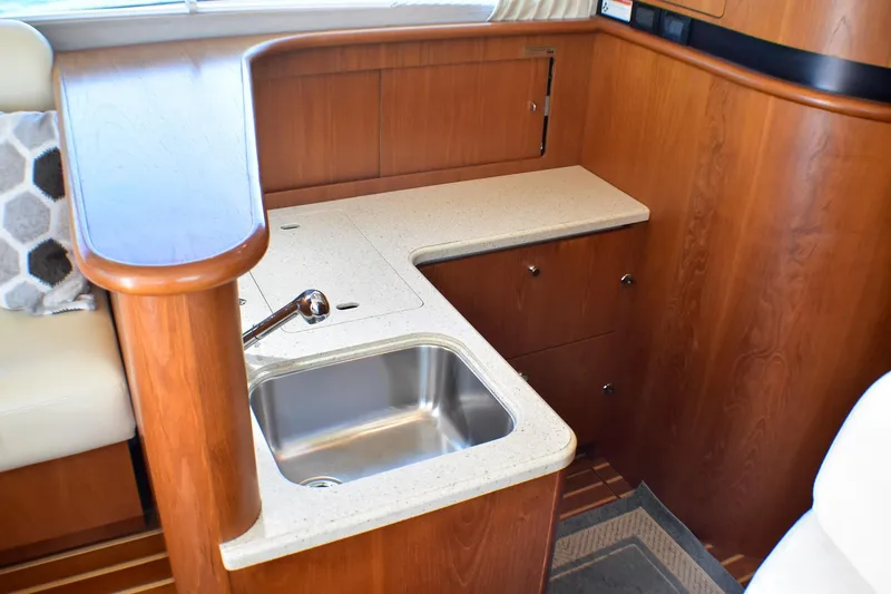 Slide: The Image of 2006 Tiara Yachts 3900 Convertible interior with wooden cabinetry and compact sink. - 17