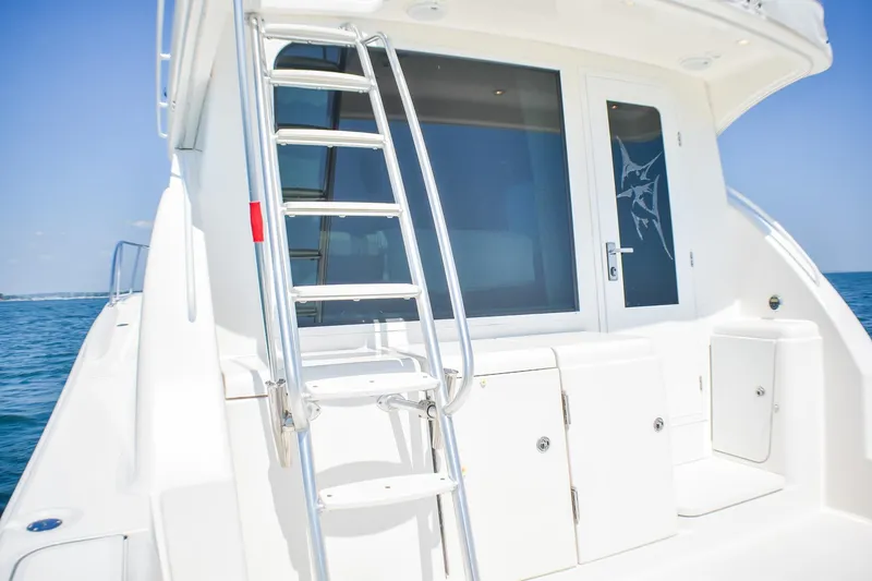 Slide: The Image of 2006 Tiara Yachts 3900 Convertible, rear view with ladder and ocean backdrop. - 27