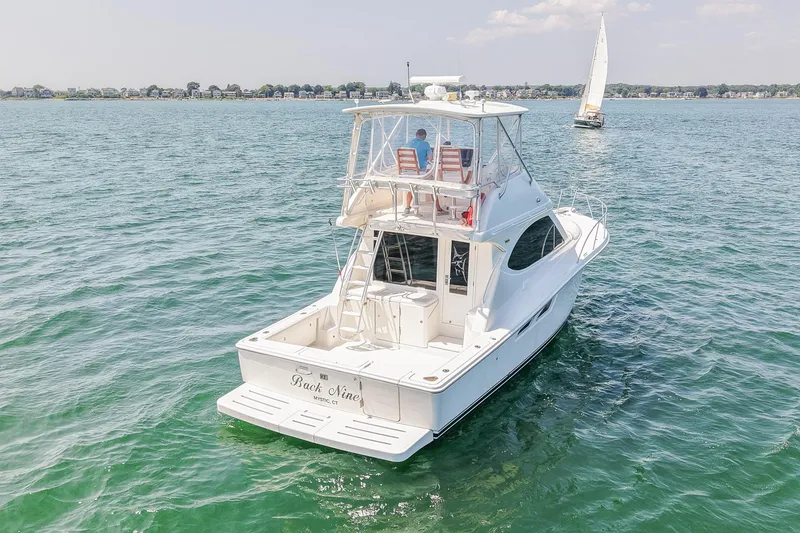 Slide: The Image of 2006 Tiara Yachts 3900 Convertible on open water with sailboat in background. - 5