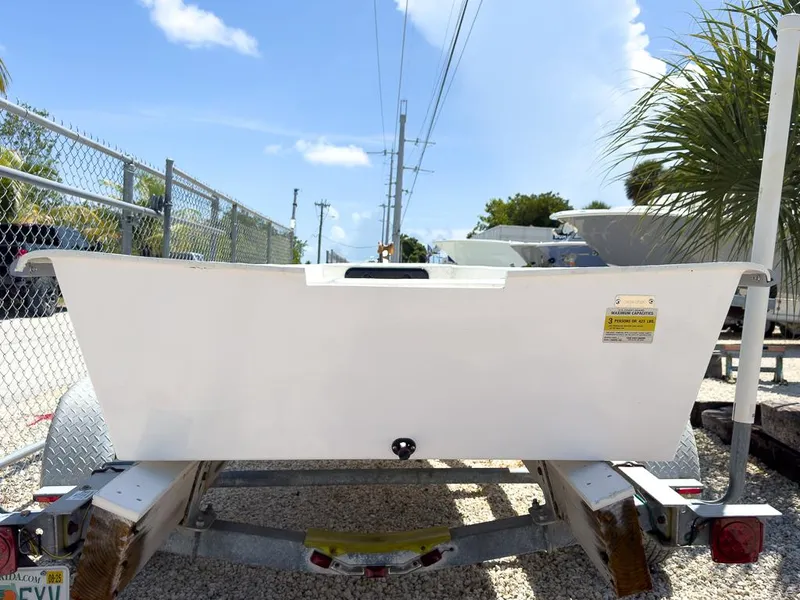 Slide: The Image of 2026 Coastal Skiff 145 on trailer, parked outdoors under clear blue sky. - 2