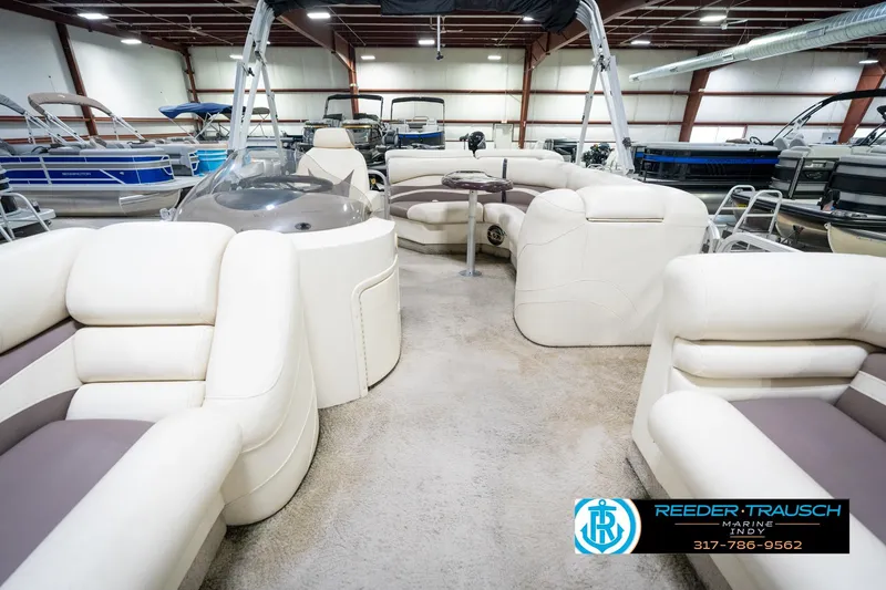 Slide: The Image of 2008 Bennington 20 SL pontoon boat interior with plush seating in a showroom. - 16