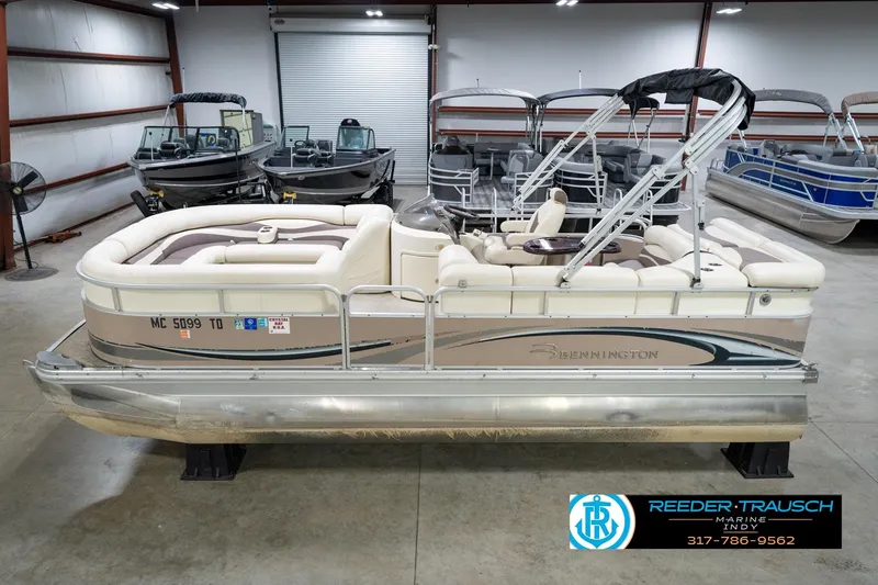 The Image of 2008 Bennington 20 SL pontoon boat in showroom, featuring beige seating and sleek design. - 2