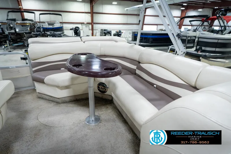 Slide: The Image of 2008 Bennington 20 SL pontoon boat interior with beige seating and a central table. - 21