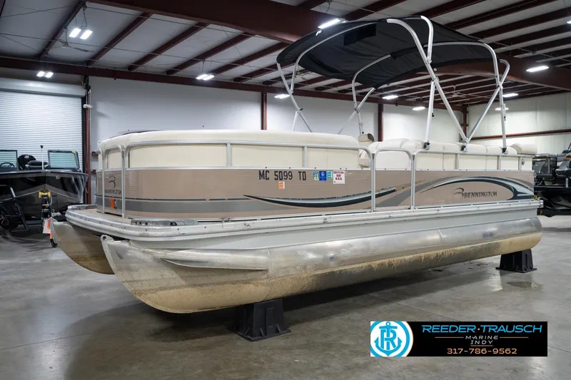 Slide: The Image of 2008 Bennington 20 SL pontoon boat in indoor showroom, featuring canopy and beige exterior. - 4