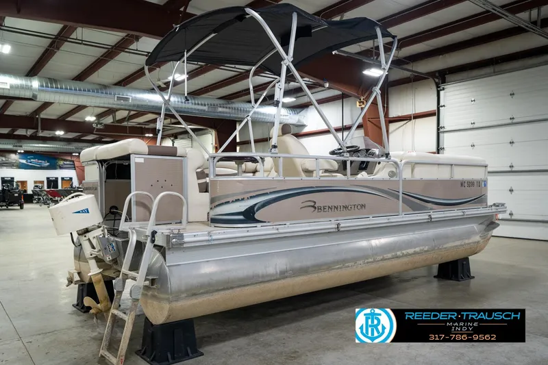 Slide: The Image of 2008 Bennington 20 SL pontoon boat in indoor showroom, featuring canopy and outboard motor. - 8