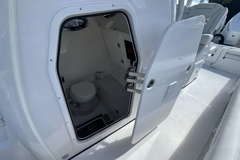 Slide: The Image of 2026 Tidewater 3100 Carolina Bay boat interior with open door to compact bathroom. - 29