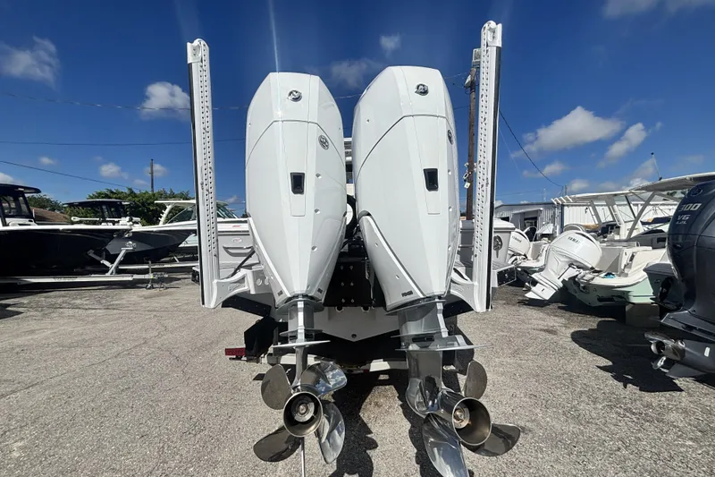 Slide: The Image of 2026 Tidewater 3100 Carolina Bay boat with dual outboard engines, parked under a clear blue sky. - 3