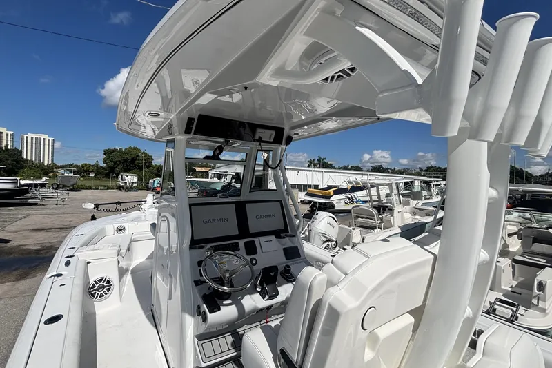 Slide: The Image of 2026 Tidewater 3100 Carolina Bay boat with Garmin navigation, docked under clear blue sky. - 30