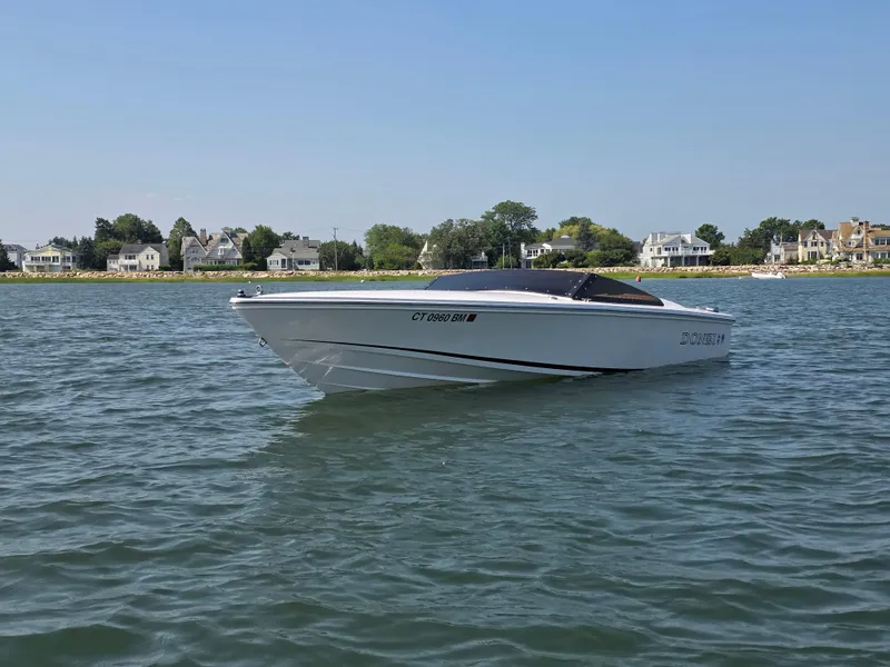 Slide: The Image of 2018 Donzi 22 Classic boat on calm water near coastal homes. - 17