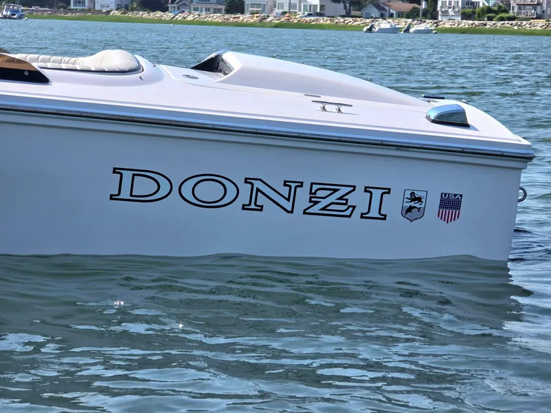 Slide: The Image of 2018 Donzi 22 Classic boat on water, showcasing sleek design and branding. - 5
