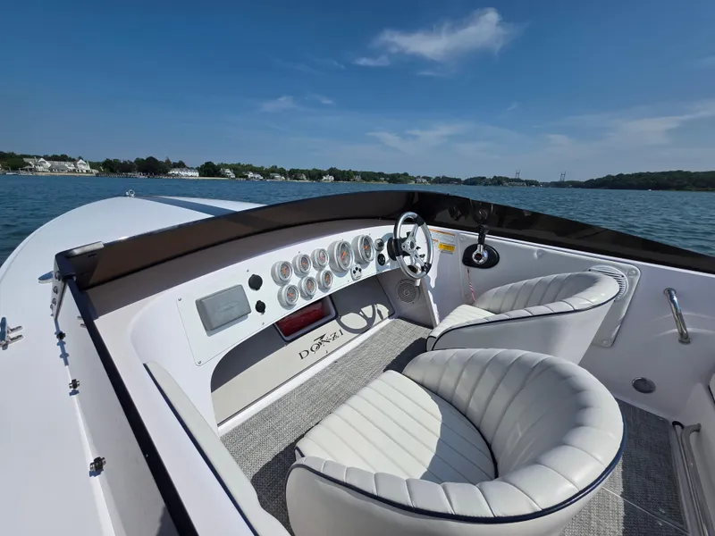 Slide: The Image of 2018 Donzi 22 Classic boat interior with white leather seats and dashboard on a sunny day. - 7