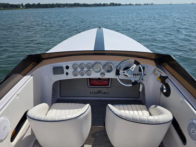 Slide: The Image of 2018 Donzi 22 Classic boat interior with steering wheel and gauges on open water. - 9