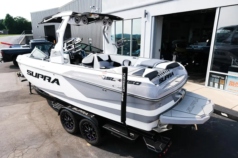 Slide: The Image of 2020 Supra SL450 boat on trailer outside showroom, featuring sleek design and modern amenities. - 3
