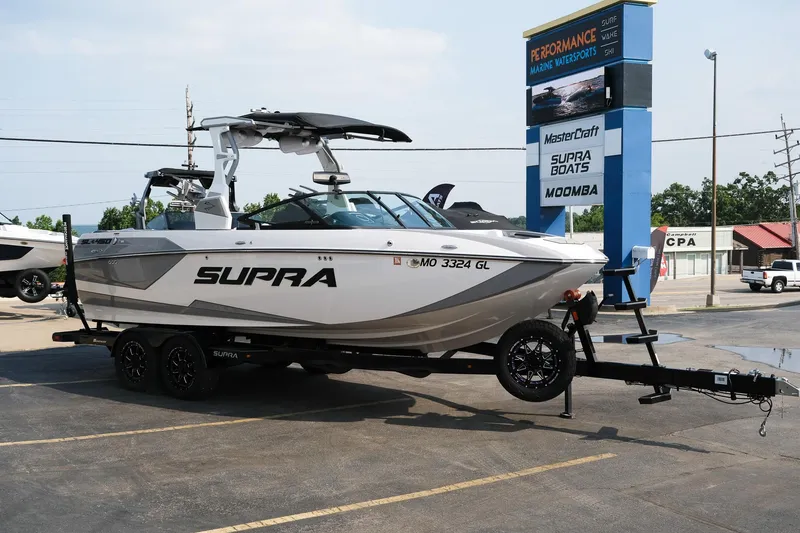 Slide: The Image of 2020 Supra SL450 boat on trailer at dealership, featuring sleek design and modern features. - 31