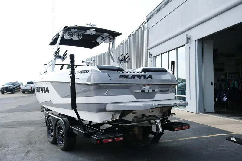 Slide: The Image of 2020 Supra SL450 boat on trailer outside a building. - 4