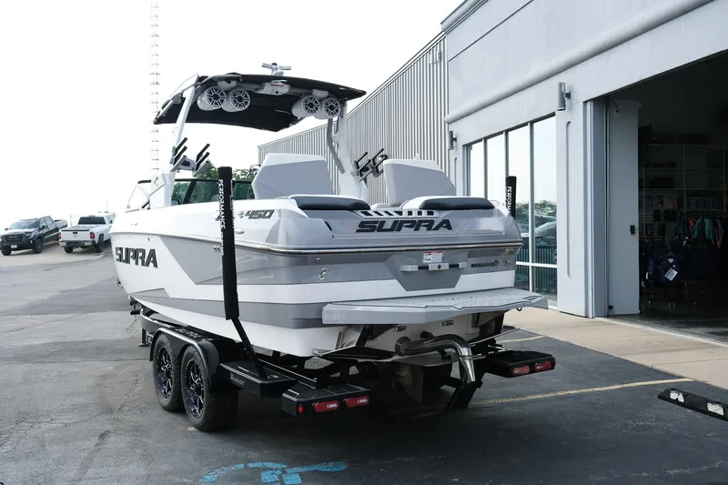 Slide: The Image of 2020 Supra SL450 boat on trailer outside a showroom. - 5