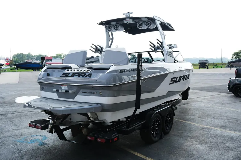 Slide: The Image of 2020 Supra SL450 boat on trailer, rear view, parked outdoors. - 7