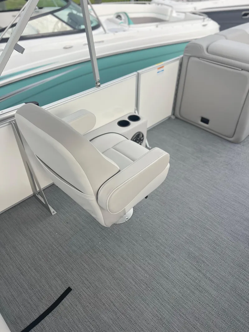 Slide: The Image of 2026 Sweetwater 2286SFLC boat interior with gray seating and carpet, featuring cup holders. - 10